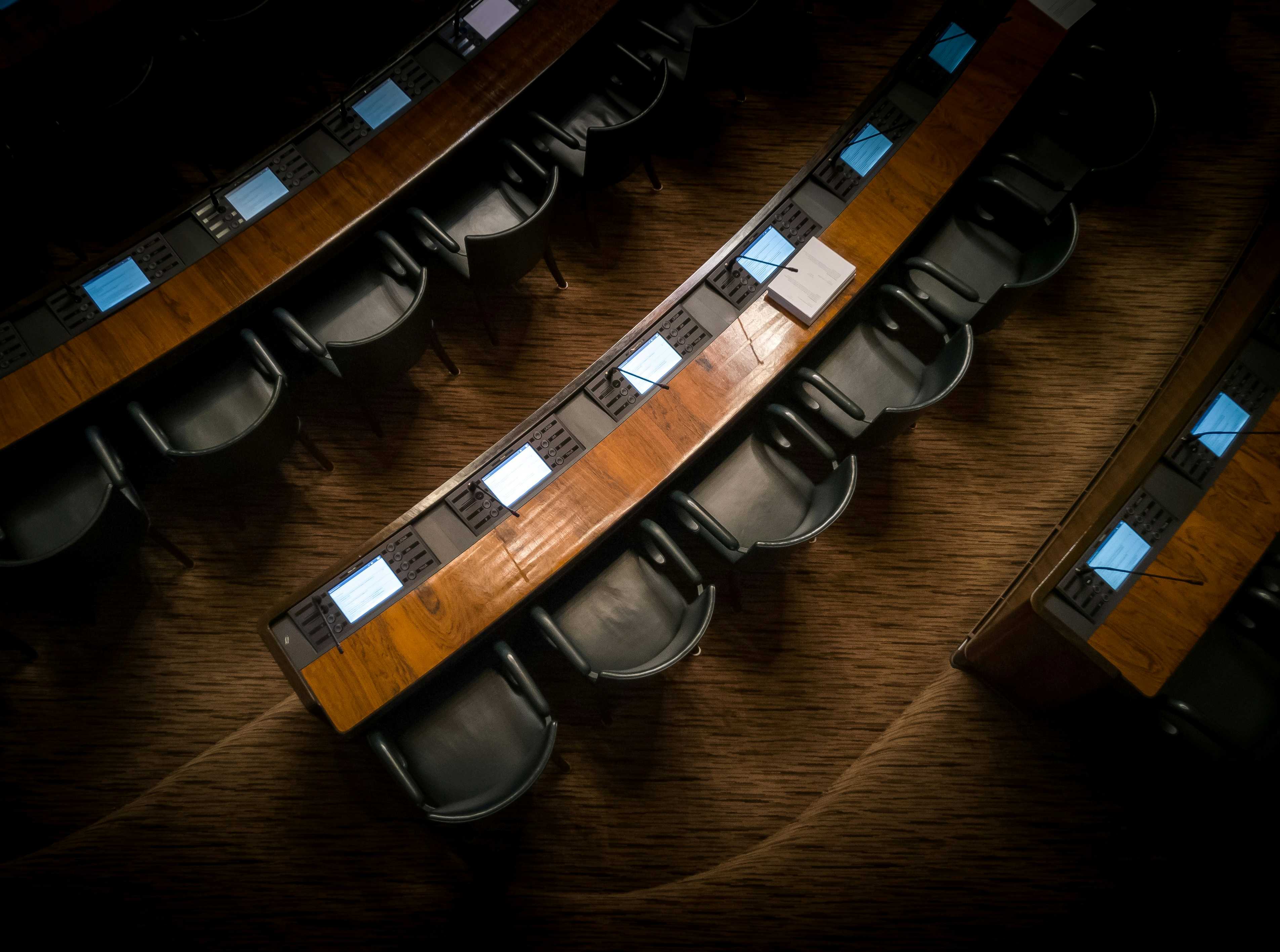 A row of empty wooden chairs in low warm light &ndash; the small circle prepared for the next workshop