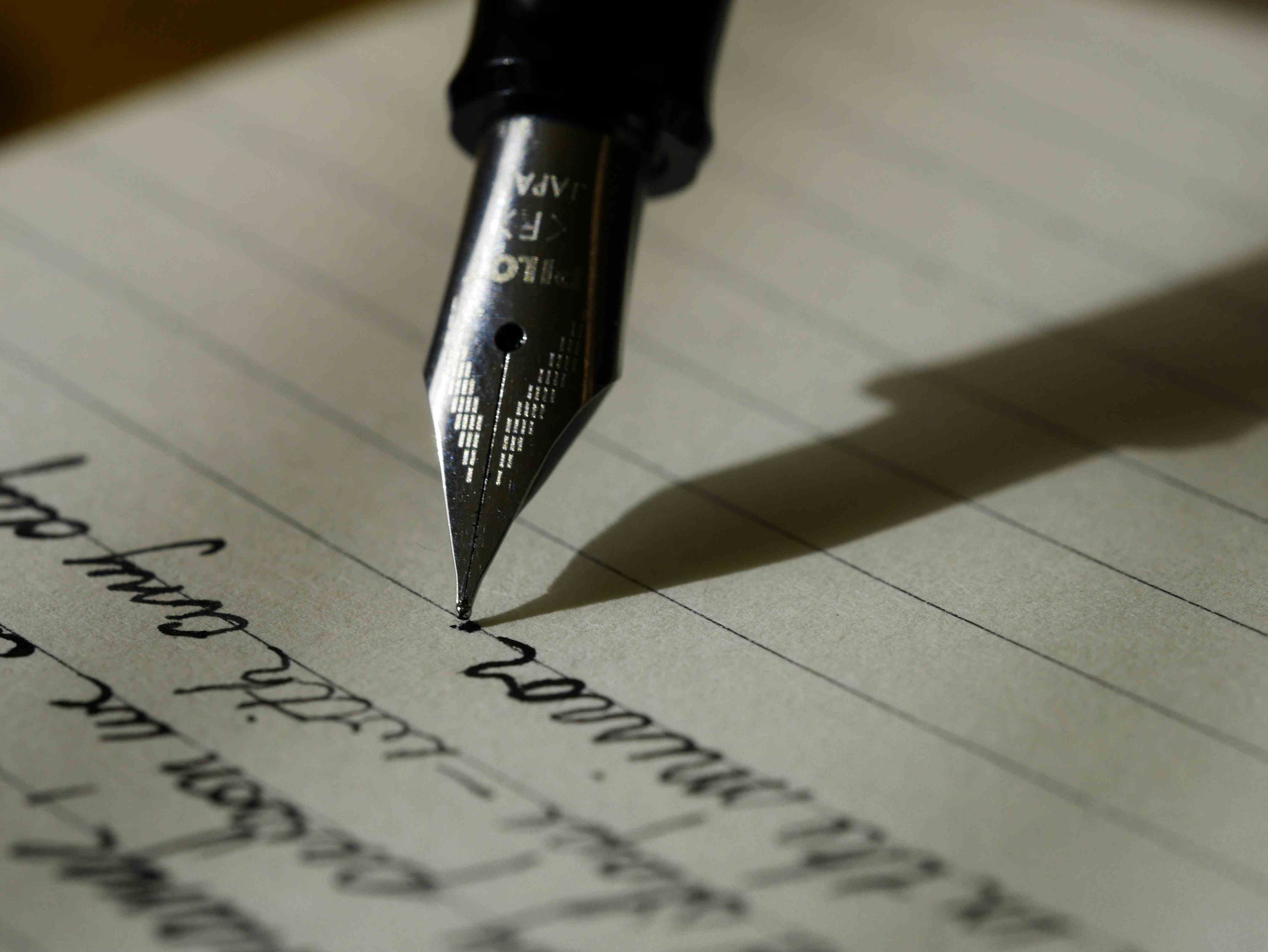 A quiet desk with an open notebook and a fountain pen in soft natural light